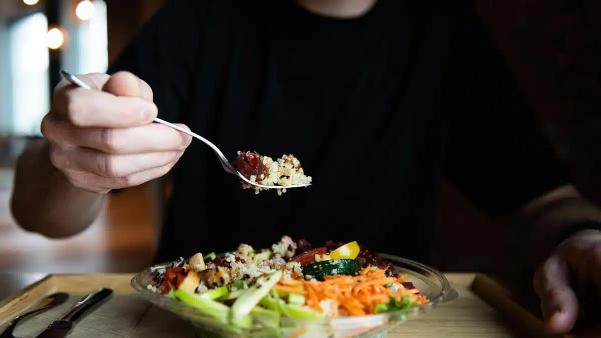 Une personne prend une fourchette de salade servie à l'Espace Saveurs