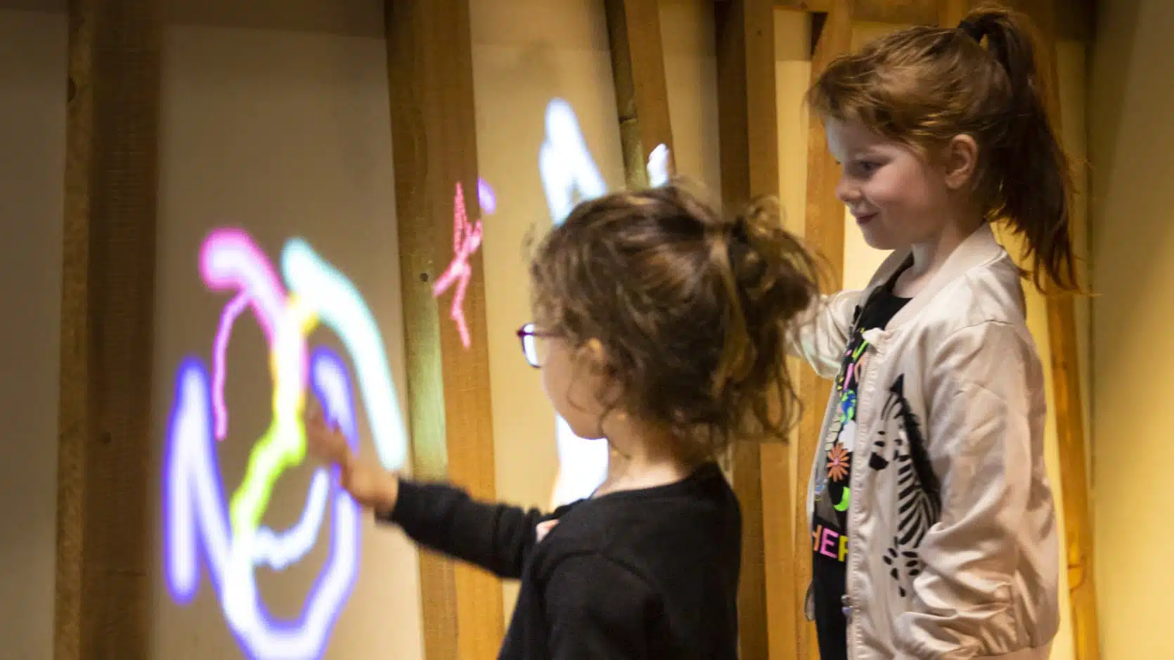 Deux jeunes filles faisant des graffitis virtuels dans l'exposition. jeunesse Ma maison
