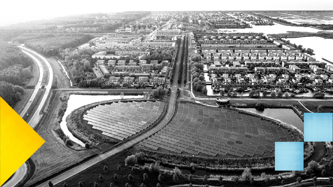 Photo en noir et blanc d'une vue aérienne d'une ville aux allures légèrement futuristes.