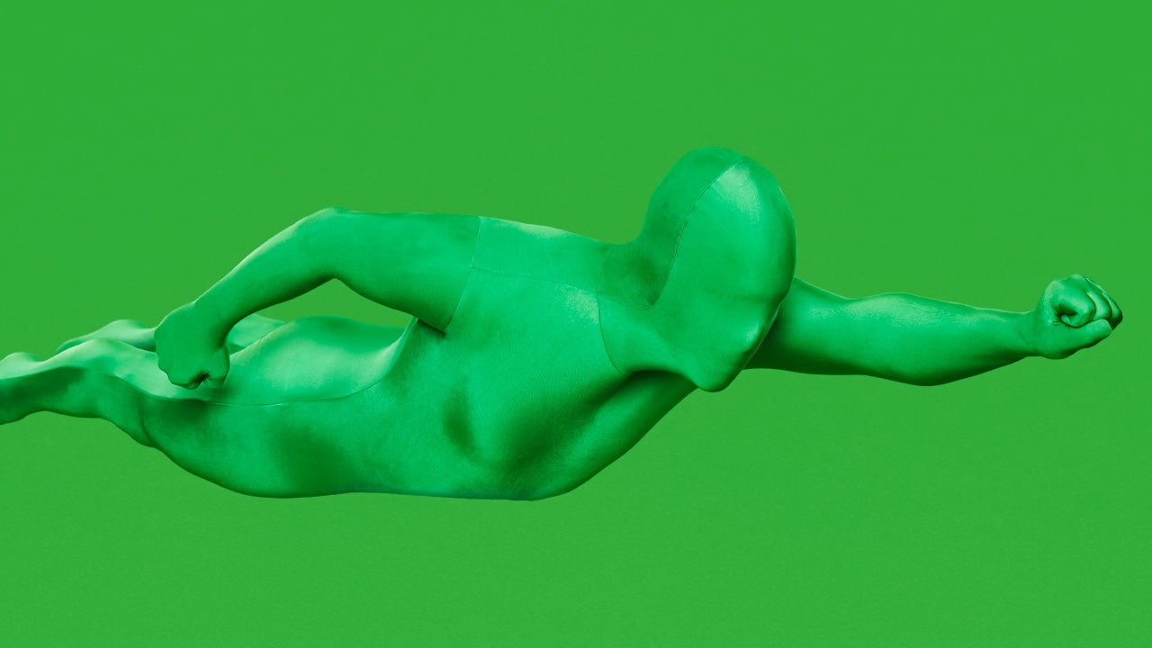 Homme vert en position de Superman sur fond vert utilisé pour les effets spéciaux .