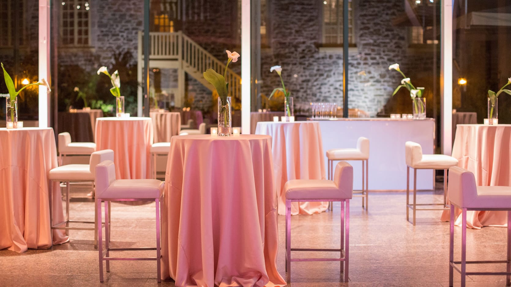 Hall du Musée en formule cocktail romantique avec des tables hautes nappées en rose pour deux personnes.