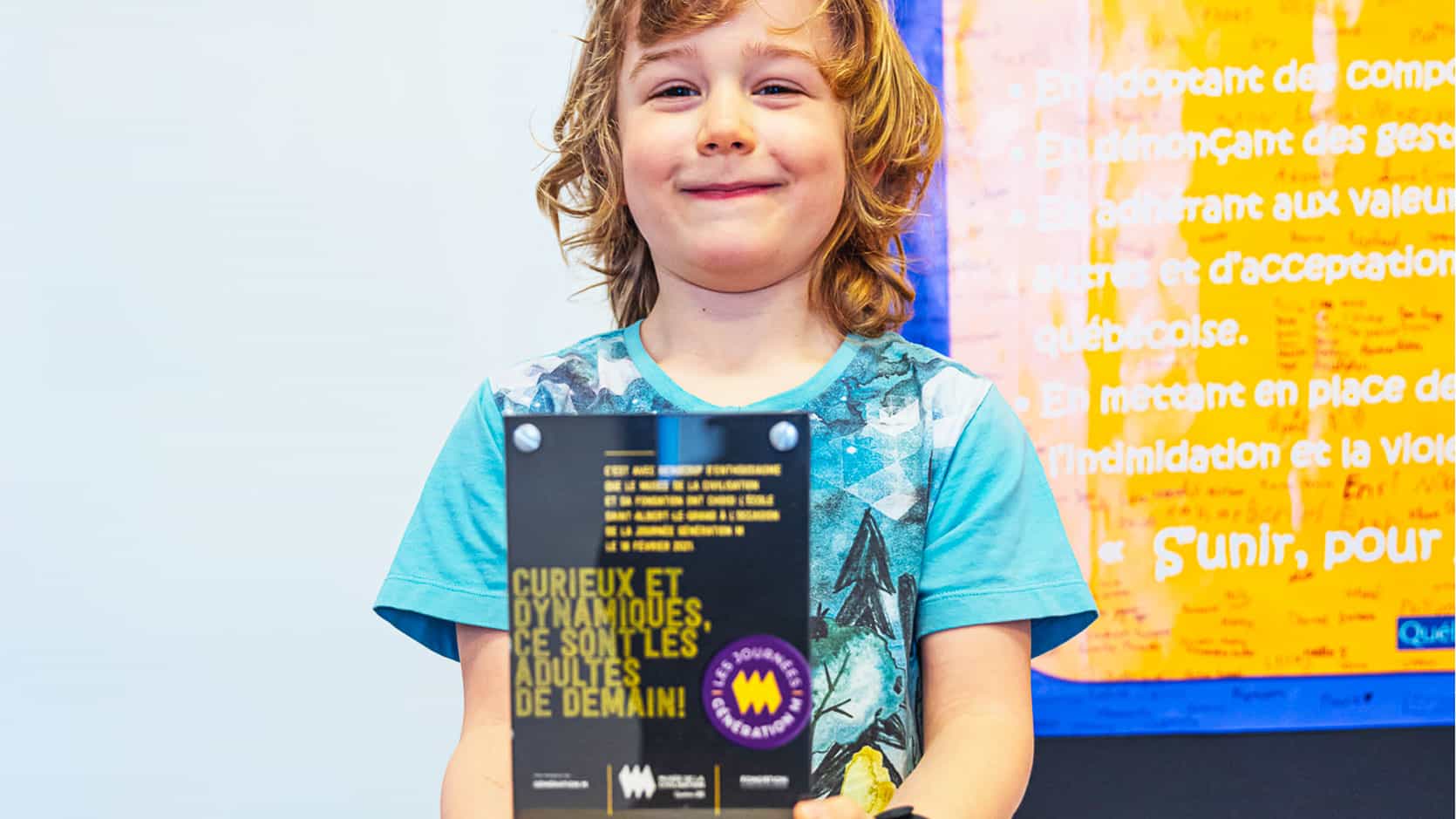 Jeune garçon souriant qui tien une affiche d'une Journée Génération M