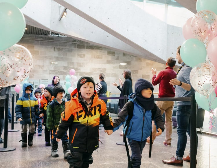 Enfants accueillis au Musée par une haie d'honneur avec des ballons lors d'une Journée Génération M