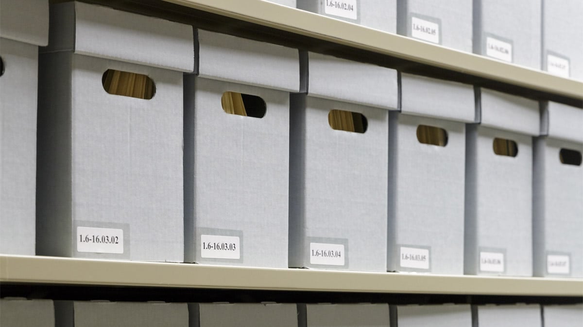 Aperçue de la réserve des documents. On y voit des boîtes en carton non acide dans lesquelles sont rangés des dossiers contenant des archives.