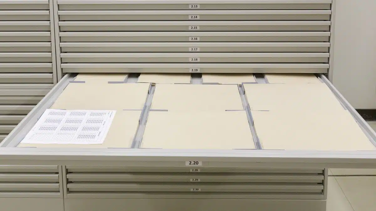Dans la réserve des oeuvres sur papier, un grand tiroir est ouvert montrant des cartons non acides dans lesquels sont rangés les oeuvres.