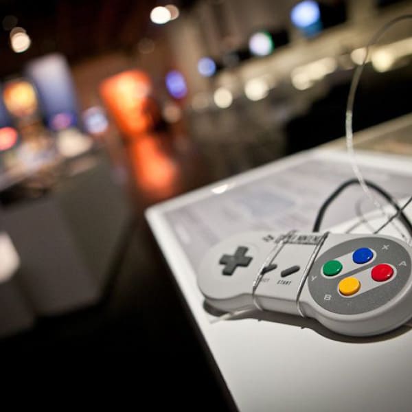 Photo d'un manette de console de jeu vidéo placée en vitrine dans une salle d'exposition