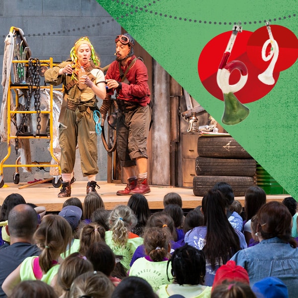 Un spectacle pour les enfants avec vue sur la scène où se trouvent un homme et une femme déguisés en explorateur devant un public d'enfants assis au sol