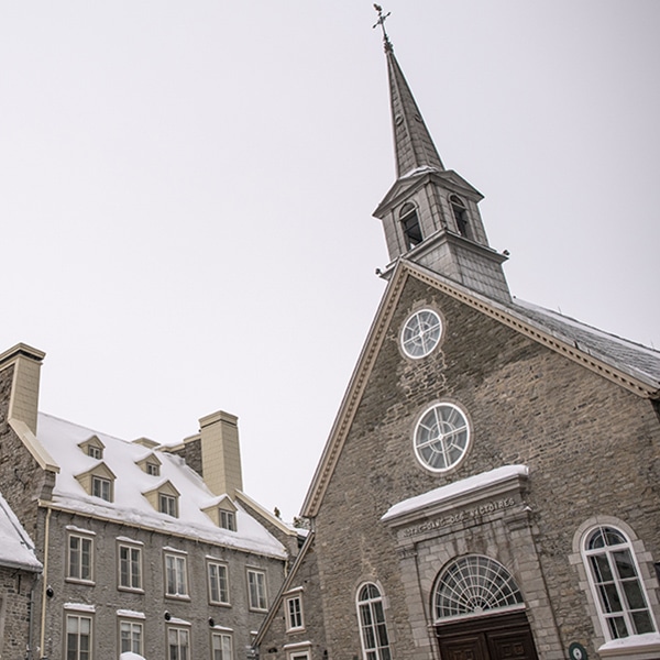 vue de l'église et des édifices environnants de Place-Royale en hiver où l'on voit la neige sur les toits