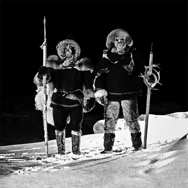 photo en noir et blanc de deux personnages issus de la tradition inuit du Labrador se tenant debout dans la neige