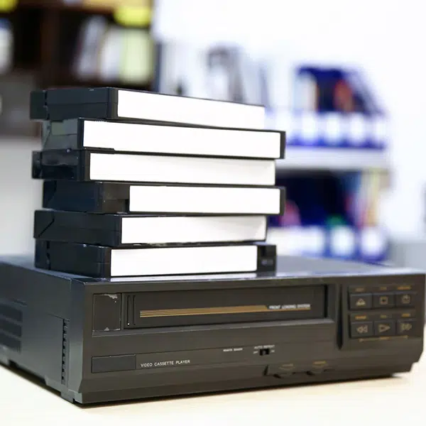 Six cassettes VHS sont empilées sur un lecteur