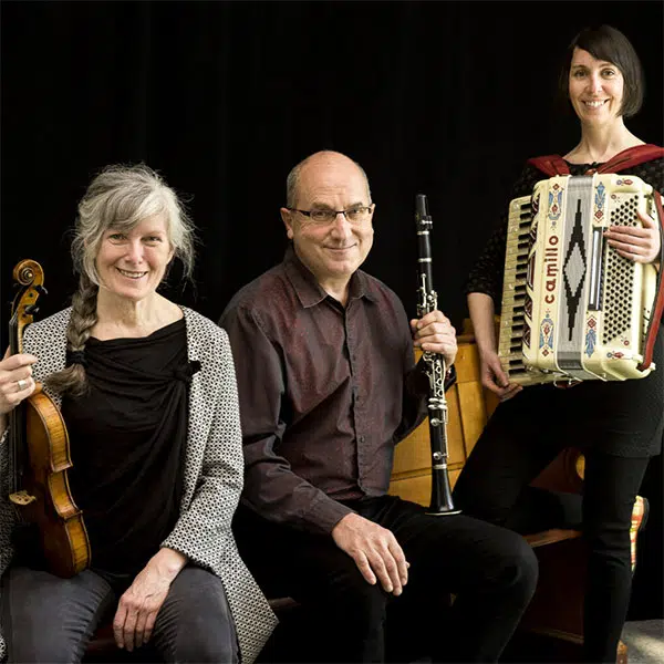 photographie portrait d'un trio musical composé d'une violoniste, d'une accordéoniste et d'un homme qui joue de la clarinette