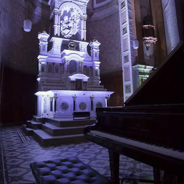 photo de la scène de la Chapelle avec l'autel en arrière-plan et un piano à queue devant