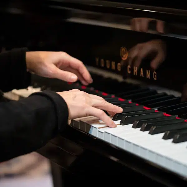 photo couleurs en grand plan sur les mains d'une personne qui joue du piano