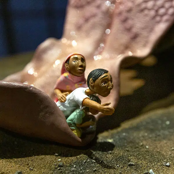 Figurines miniatures représentant Mohammed Shofi, un réfugié rohingya, sa mère et son petit frère, agenouillés