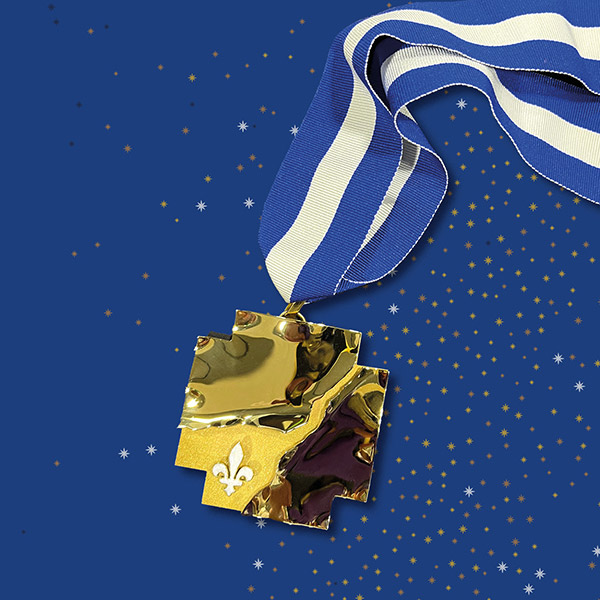 Médaille dorée de l'Ordre nationale du Québec avec un ruban bleu rayé blanc sur un fond bleu étoilé
