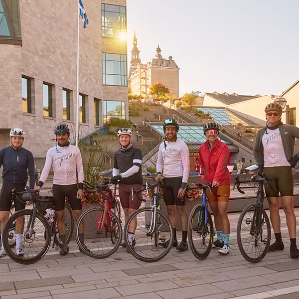 Six cyclistes posent à côté de leur vélo sur le parvis du Musée