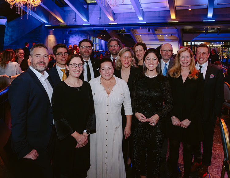 12 personnes membres du C.A. de la Fondation du Musée sont alignées dans le Hall du Musée lors du Grand Banquet le 21 novembre 2025.