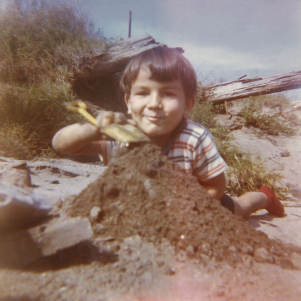 Photographie utilisée pour illustrer l'exposition du Port de Québec sur l'Anse au Foulon. Elle montre un enfant en train de faire unchateau de sable.