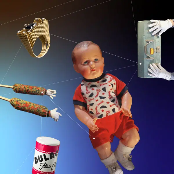 Montage d'objets sur un fond bleu foncé : une bague, de longs bras, une poupée de cire et une boîte d chocolat Dulac.