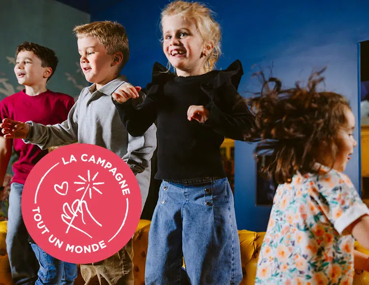 4 enfants sautent de joie sur un faux divan jaune