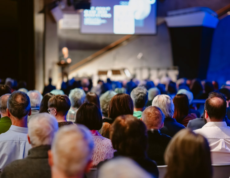 Foule nombreuse assistant à une conférence dans le Hall du Musée