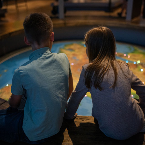 Jeune garçon et jeune fille de dos qui observe une carte aus des nations autochtones
