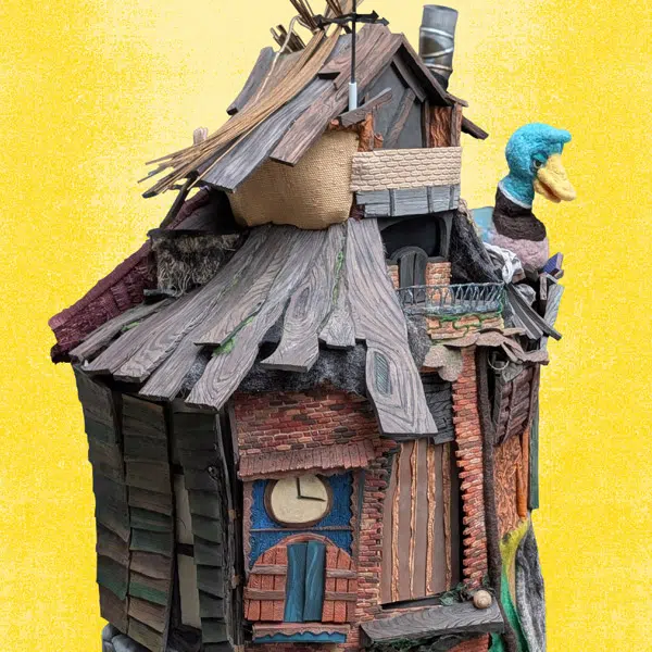 Photo qui représente une maisonnette ronde en bois avec une marionnette de canard nichée sur le toit. Visuel du spectacle déambulatoire de la Maison qui marche.